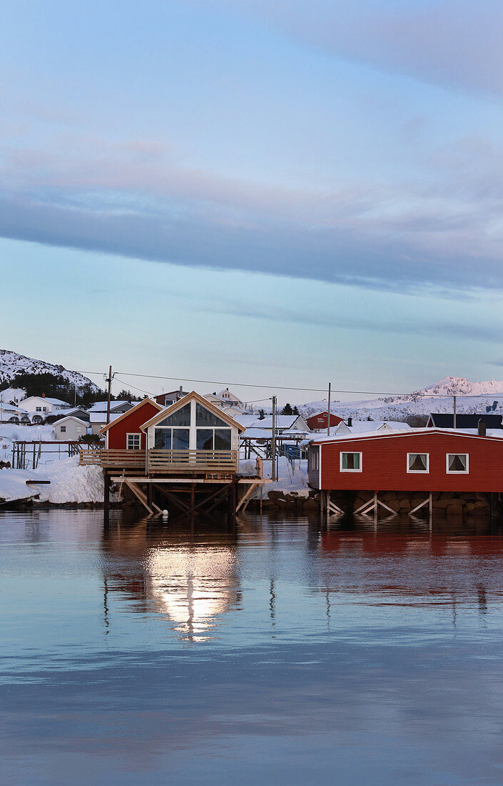 Houses with snowy roofs on wintry Norwegian fjord