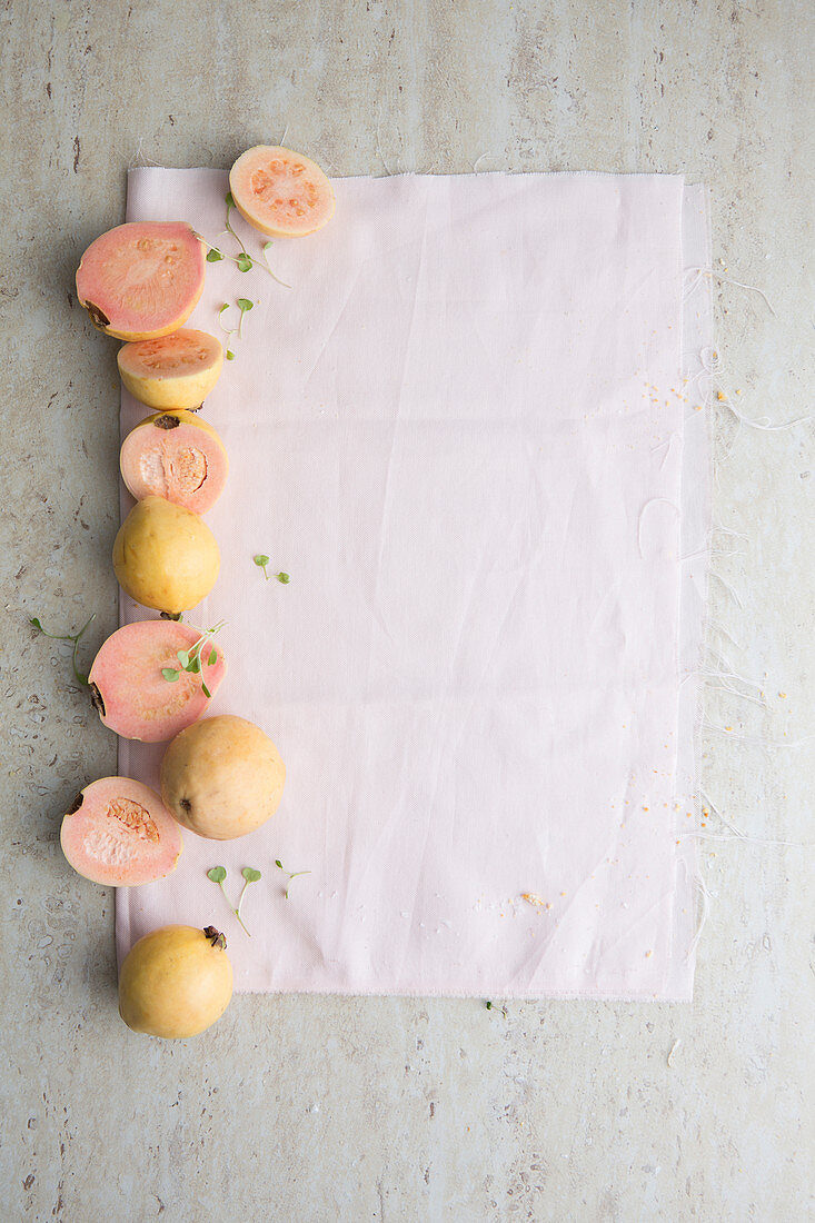 Guaven, ganz und halbiert, auf Papier