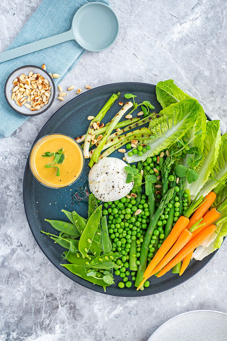 Pea salad with burrata, pine nuts, asparagus and a carrot and cumin dressing