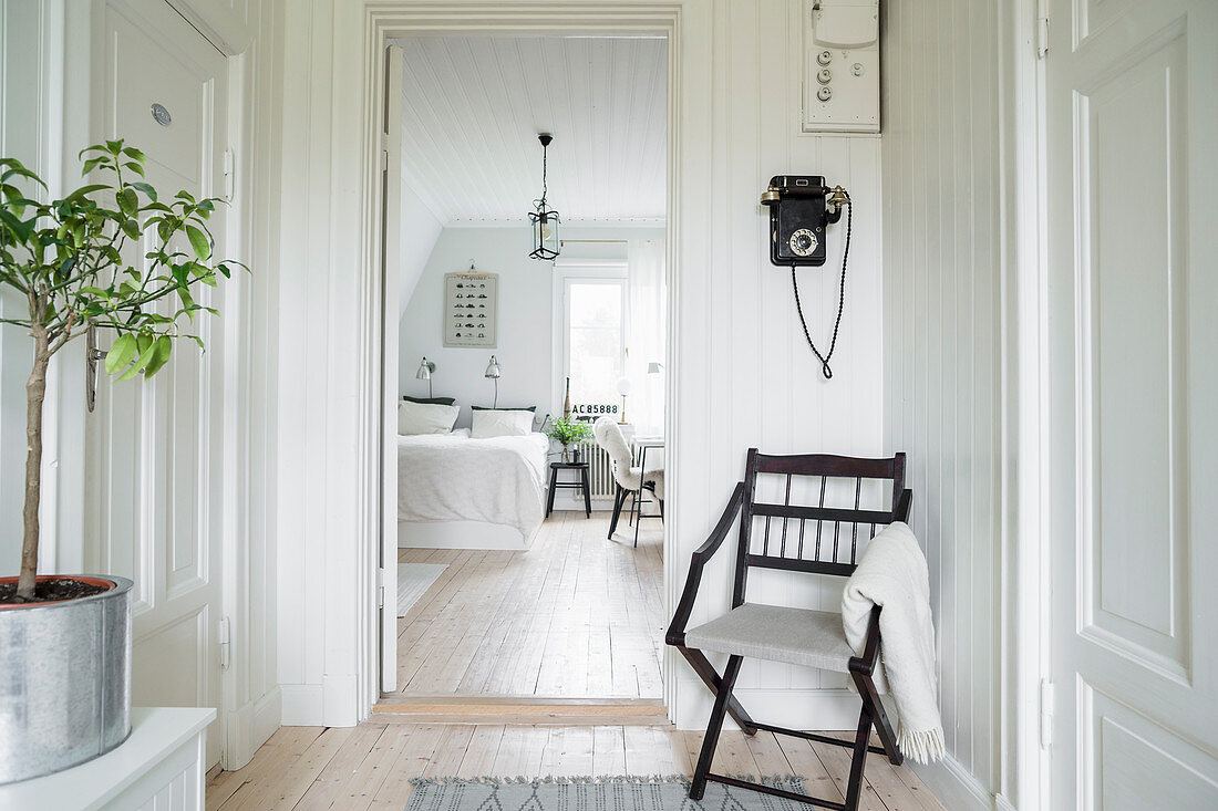 Chair next to bedroom door in hallway with period charm