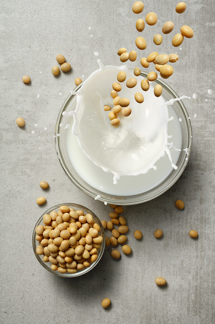 Soya beans falling into a glass of milk