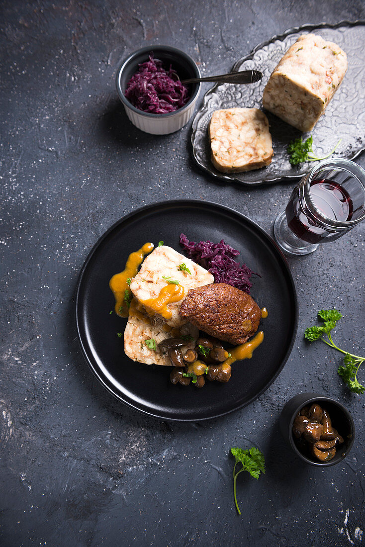 Vegan bread dumplings with soy-wheat steak, red cabbage and chestnut mushrooms