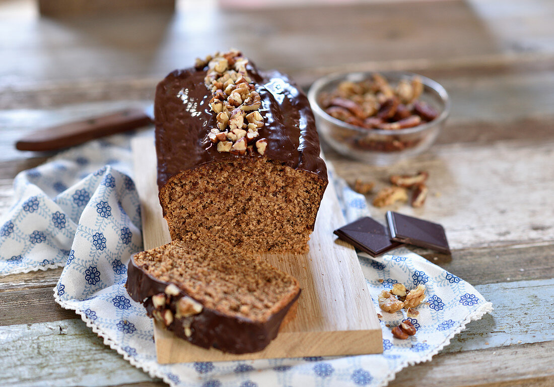 Vegan nut cake with walnuts, pecans and chocolate icing