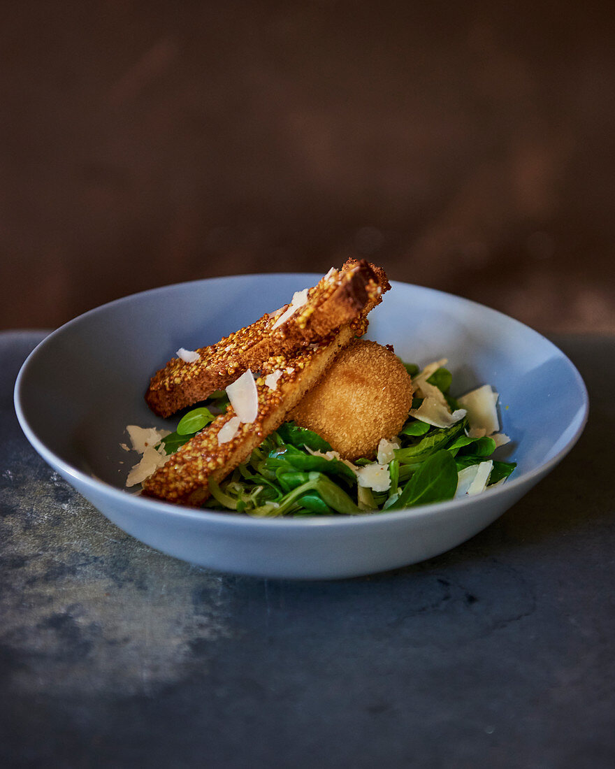 Frittierte Eier auf Salat mit Toaststreifen