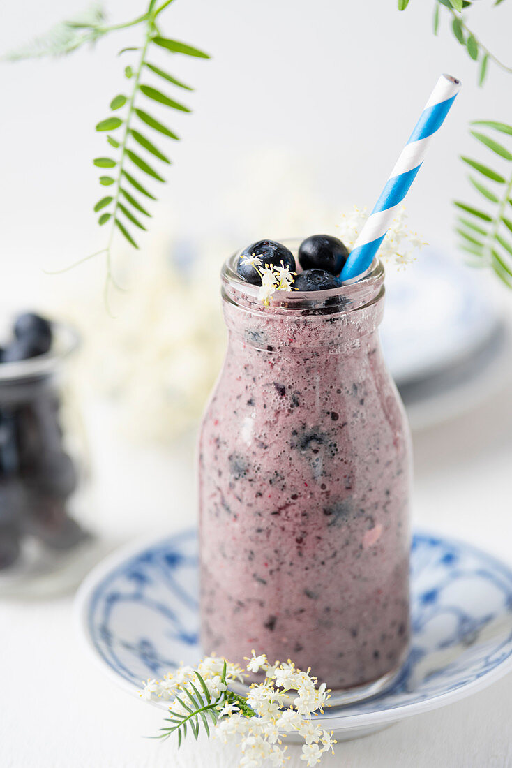 A smoothie with blueberries and elderflowers
