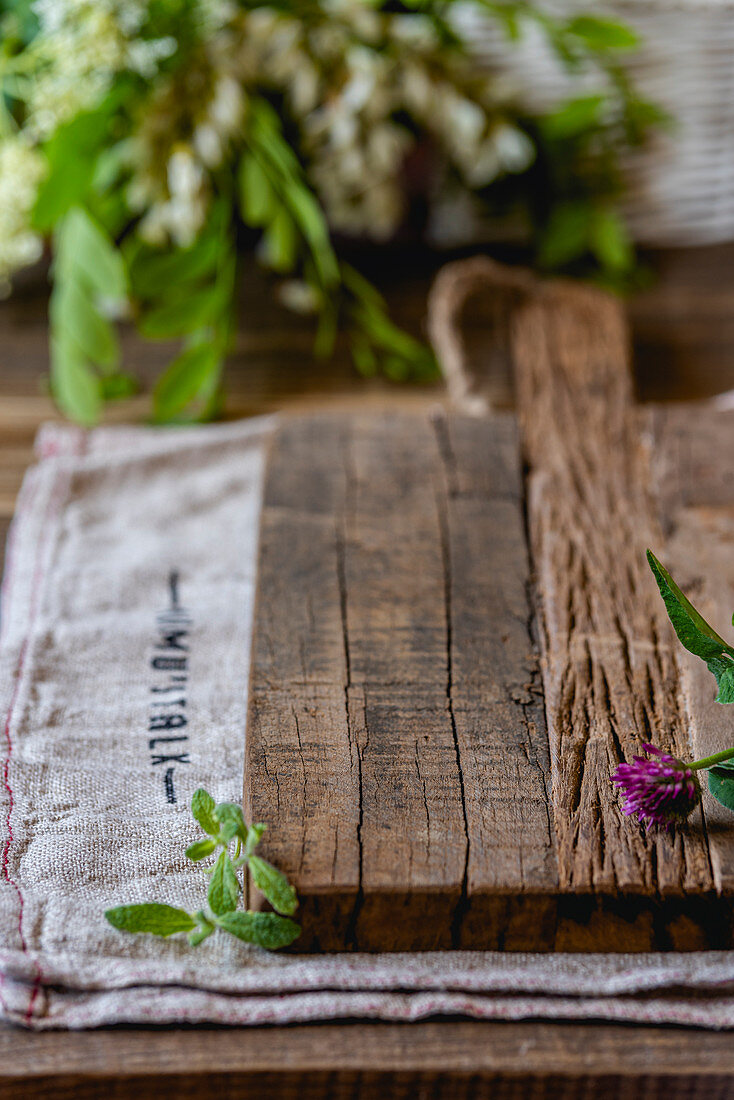 A wooden chopping board with herbs
