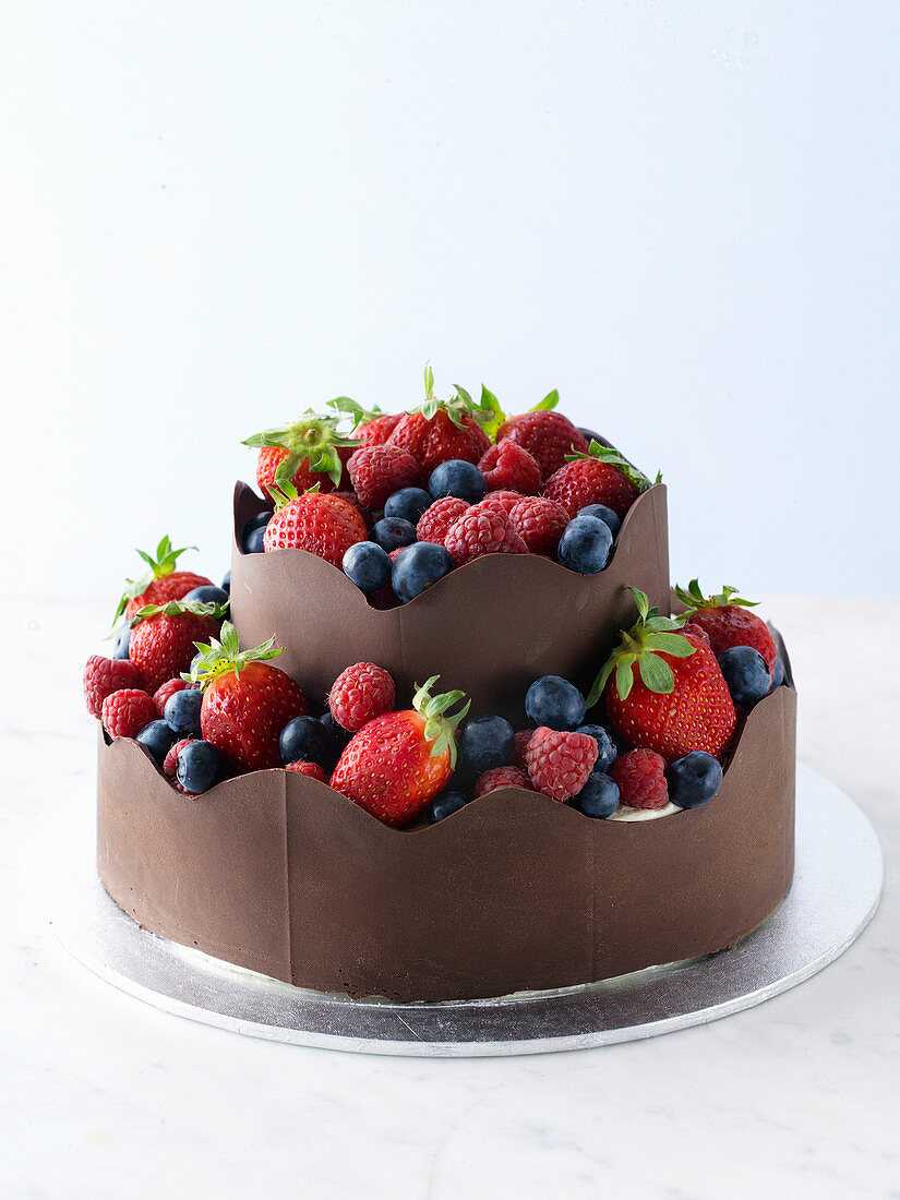 Schokoladenkuchen mit Beeren und Schokoladenbändern