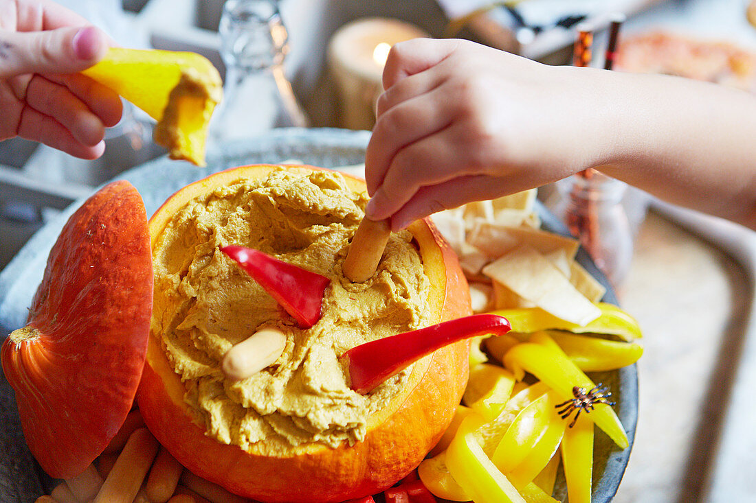 Halloween-Kürbis mit Hummus und Gemüsesticks