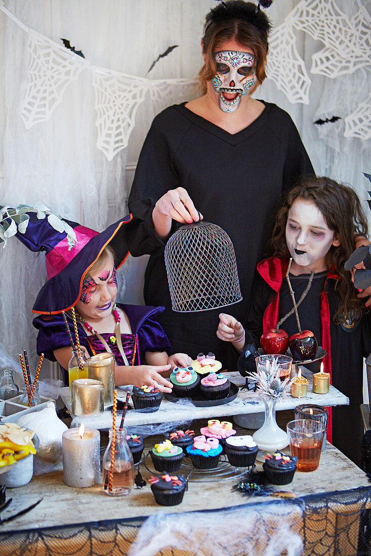Verkleidete Frau und Kinder bei einer Halloween-Party