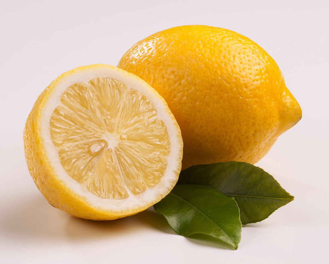 Zitrone, Zitronenhälfte und Zitronenblätter