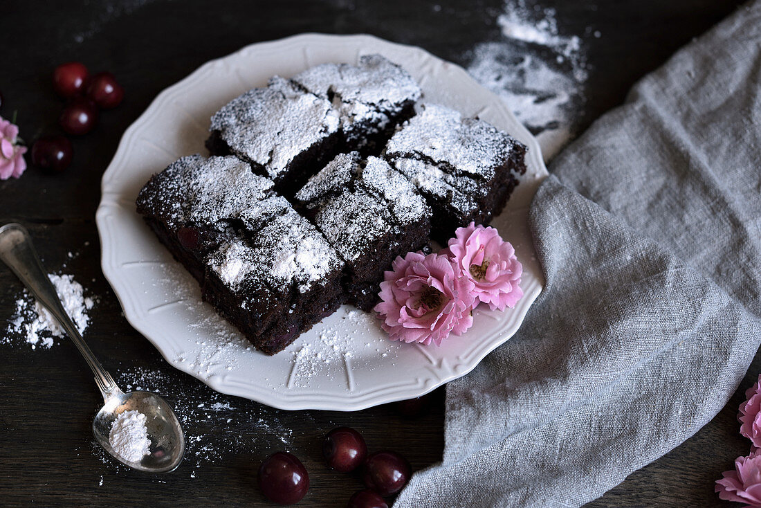 Schokoladenkuchen mit Kirschen und Puderzucker