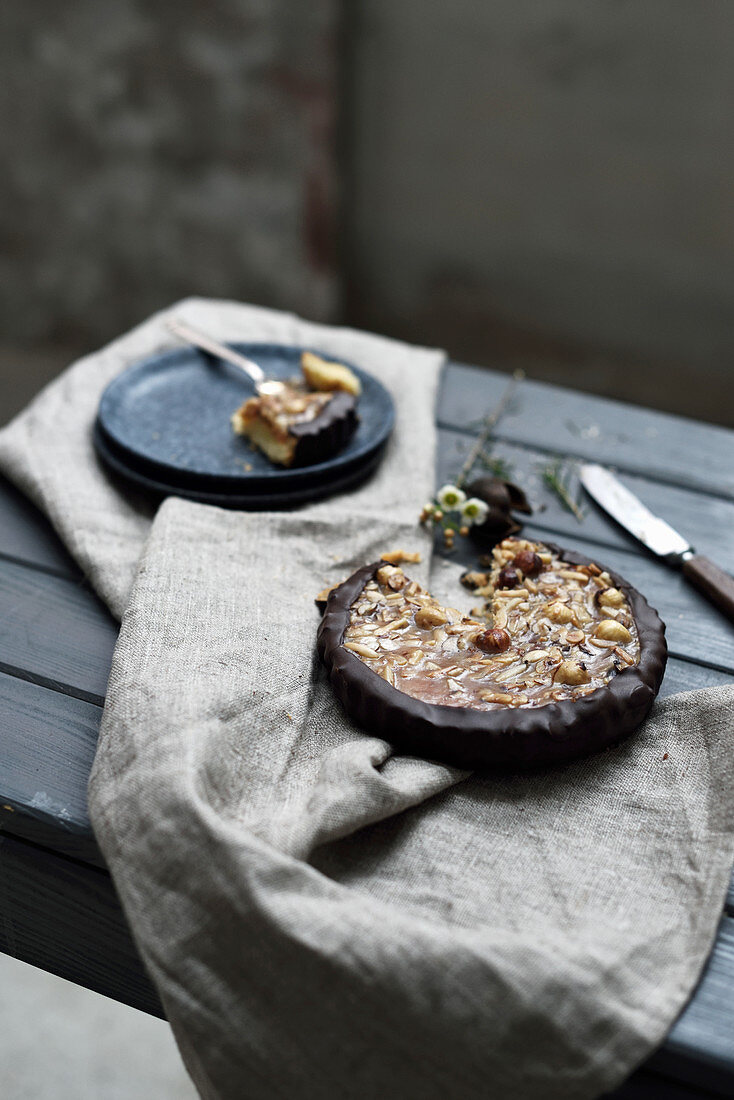 Nusskuchen mit Schokoladenrand auf rustikalem Holztisch