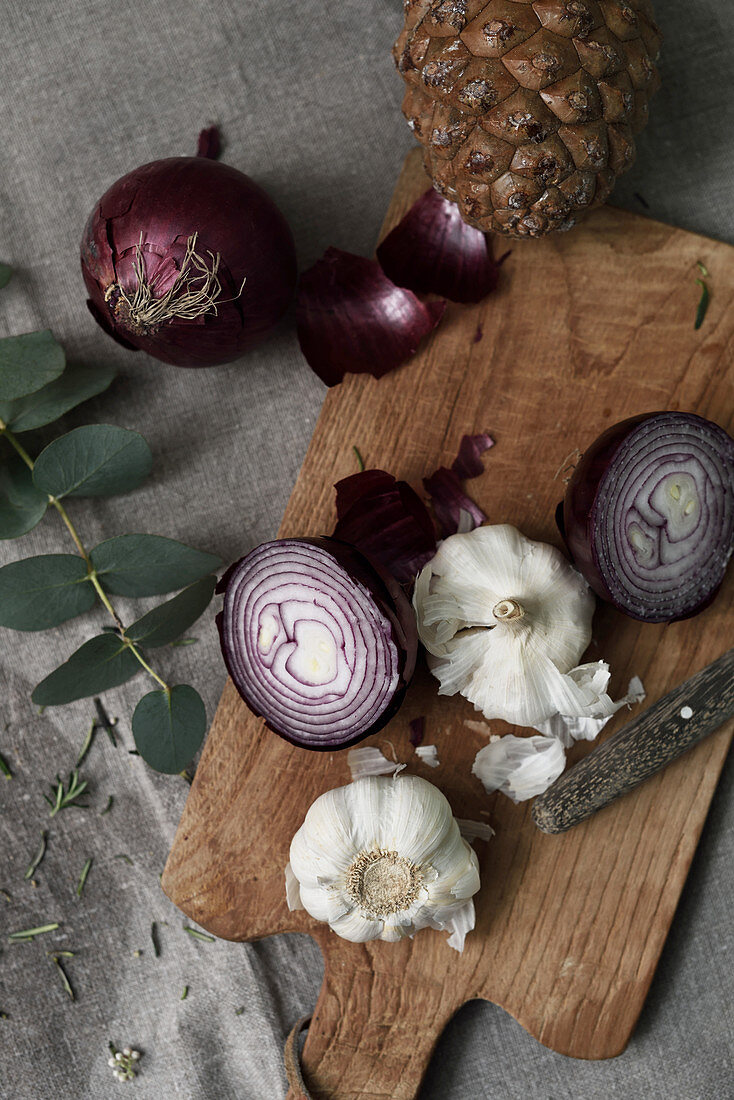 Garlic and red onions on a wooden chopping board