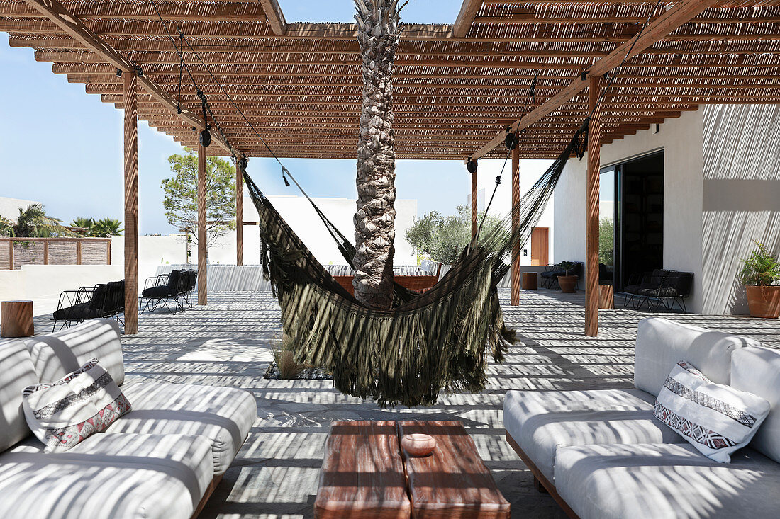 Hammocks and lounge area on terrace with thatched sun shade
