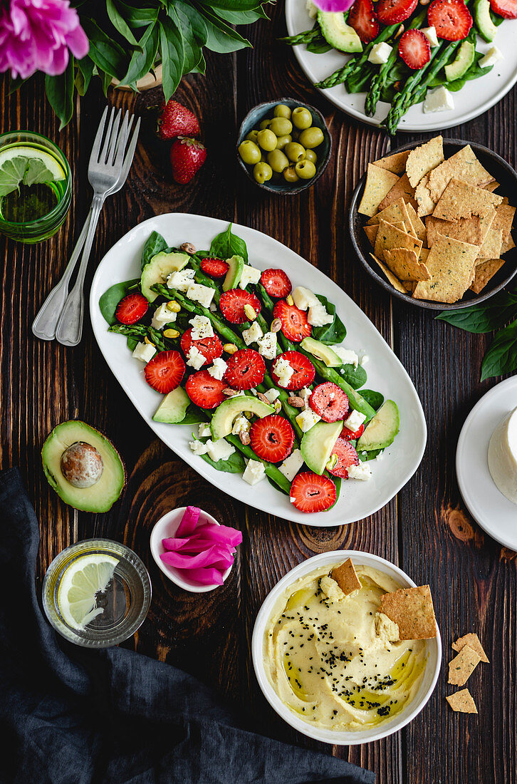 Summer salad with vegetables and strawberries, a dip and crackers