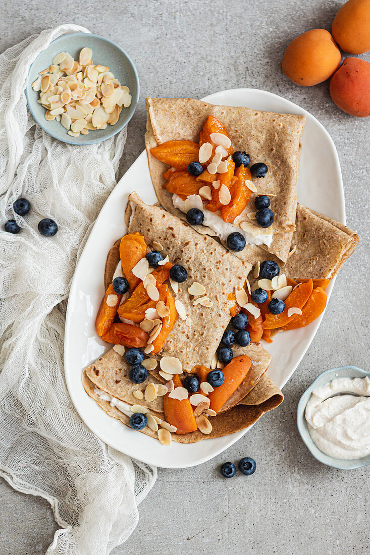 Crepes with ricotta, apricots, blueberries and flaked almonds