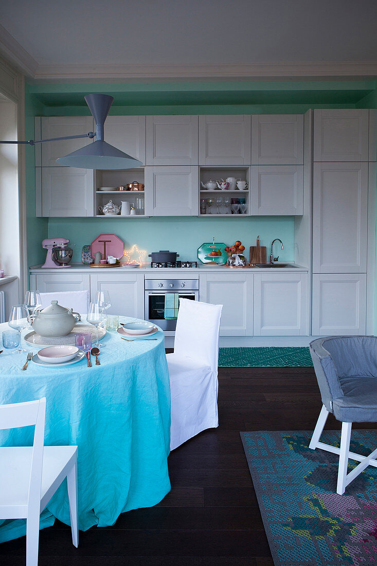 Round dining table in vintage-style kitchen in aqua shades