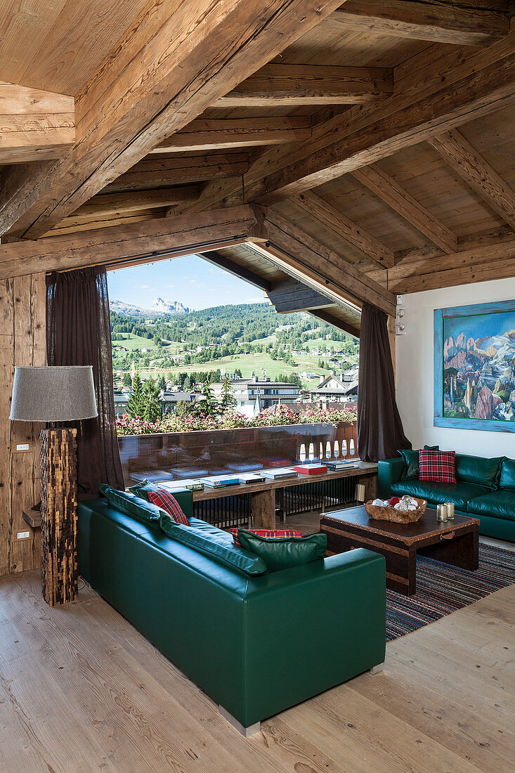 Grüne Ledersofas im Wohnzimmer in einem rustikalen Holzhaus