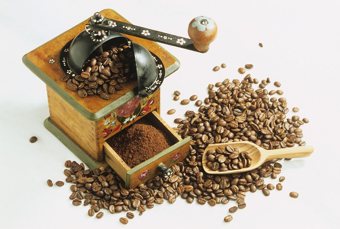 Old coffee mill with ground coffee and coffee beans