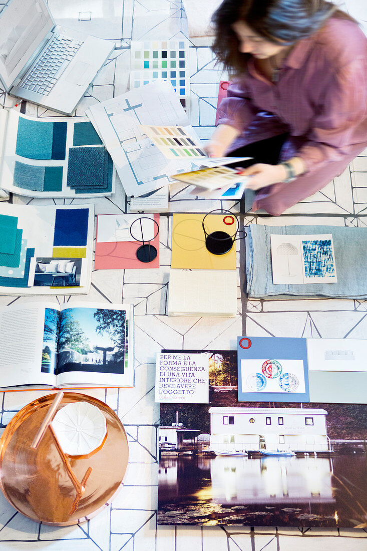 Mood board of books, fabric samples and colour palettes on floor