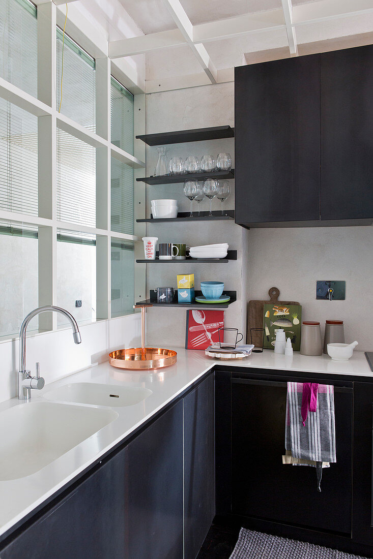 Small, modern, loft-style kitchen with black, metal cupboard doors