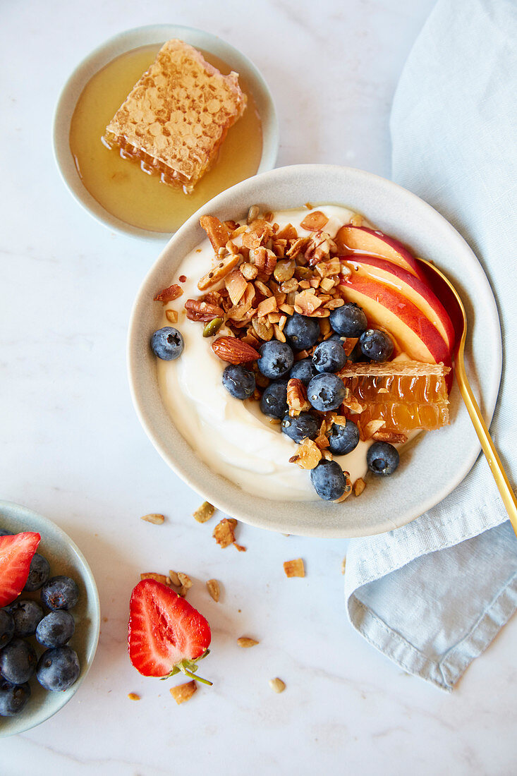 Breakfast Bowl mit Joghurt, Granola, Früchten und Honig