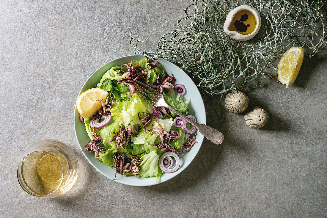 Green salad with grilled squids calamari tentacles, lemon, purple onion