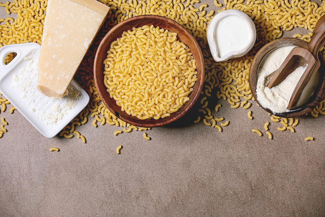 Raw uncooked italian pasta coquillettes for cooking dinner with parmesan cheese, cream and semolina flour