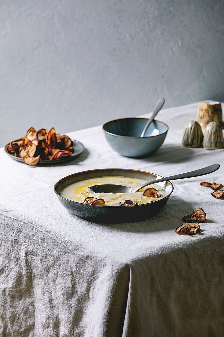Blumenkohl-Pastinakensuppe mit getrockneten Birnenscheiben auf Tisch