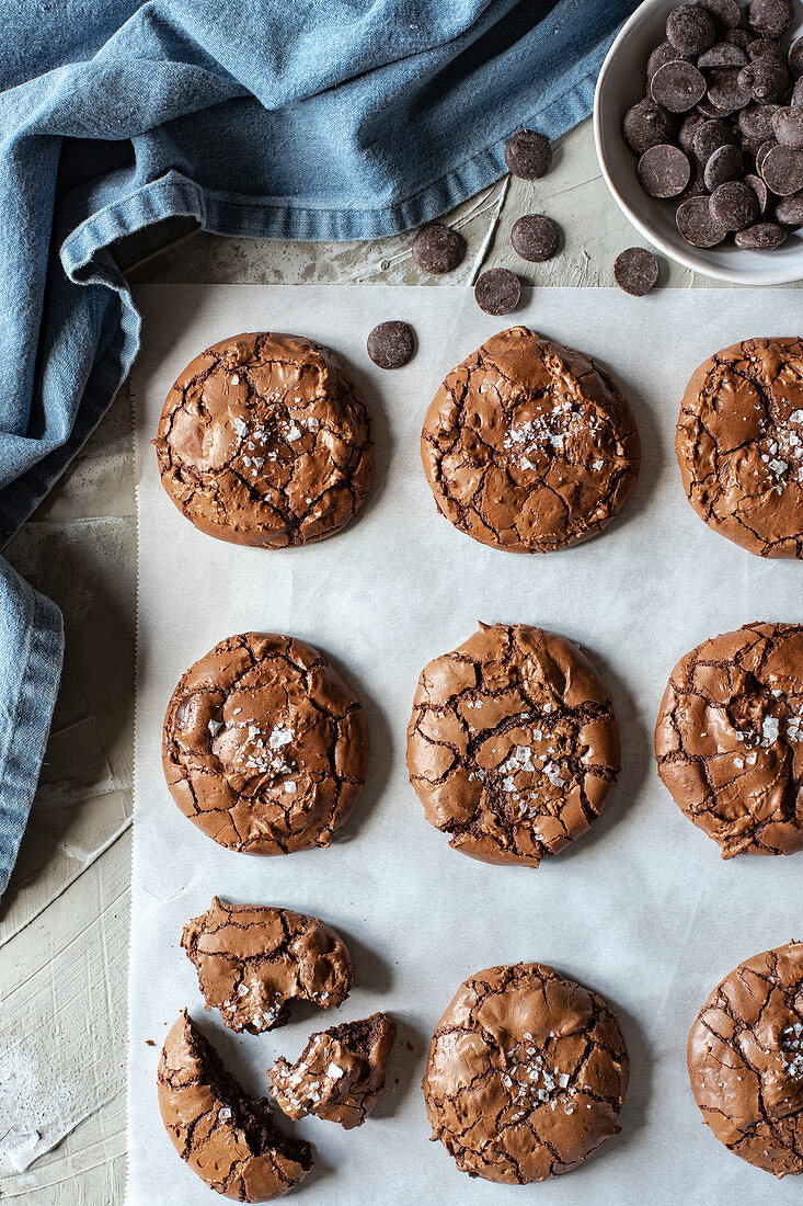 From above composition of delicious chocolate brownie cookies on white parchment and blue towel