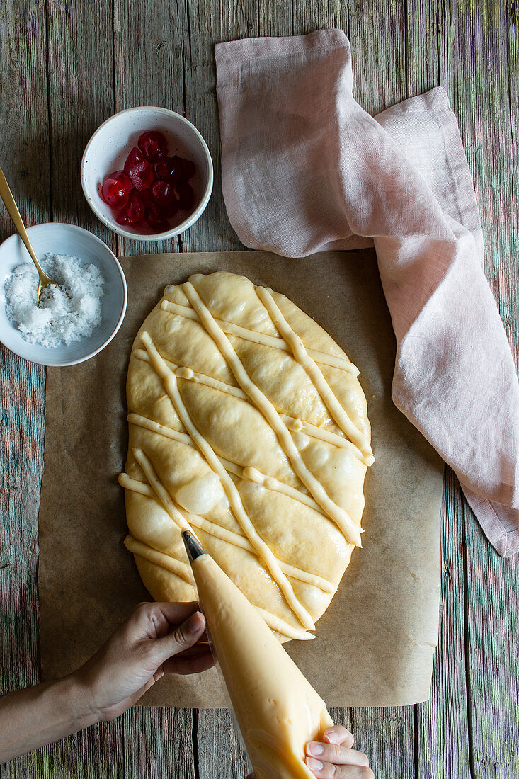 Top view of fresh Coca de San Juan pastry on timber table in rustic kitchen