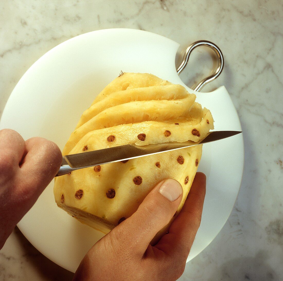 Peeling pineapple (cutting out the eyes with a spiral action)