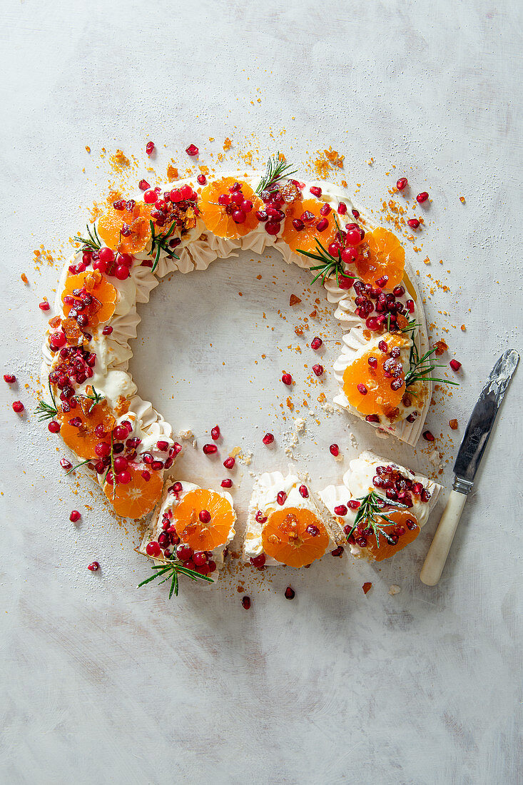 Baiserkranz mit Schlagsahne, Granatapfel, Satsumas, roten Johannisbeeren und Krokant