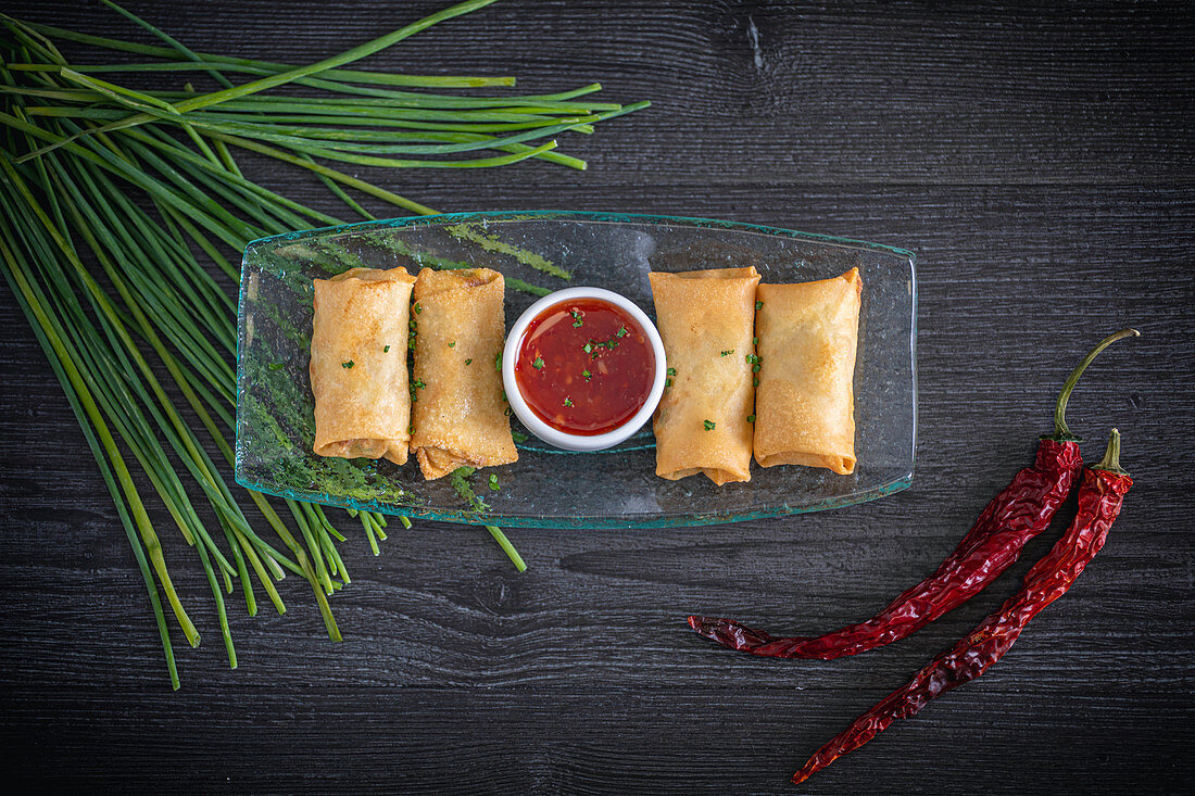 Spring rolls with a chili dip and chives (Asia)