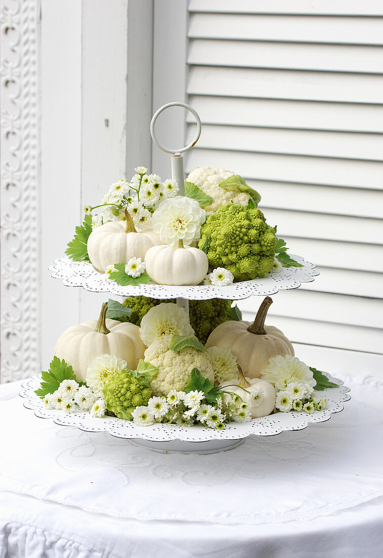 Etagere mit Dahlien, Chrysanthemen, Kürbissen, Blumenkohl und Romanesco