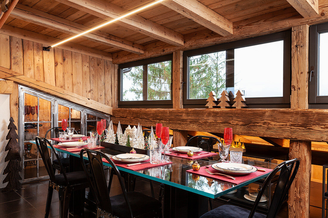 Festively set table and black, upholstered chairs in dining area of chalet