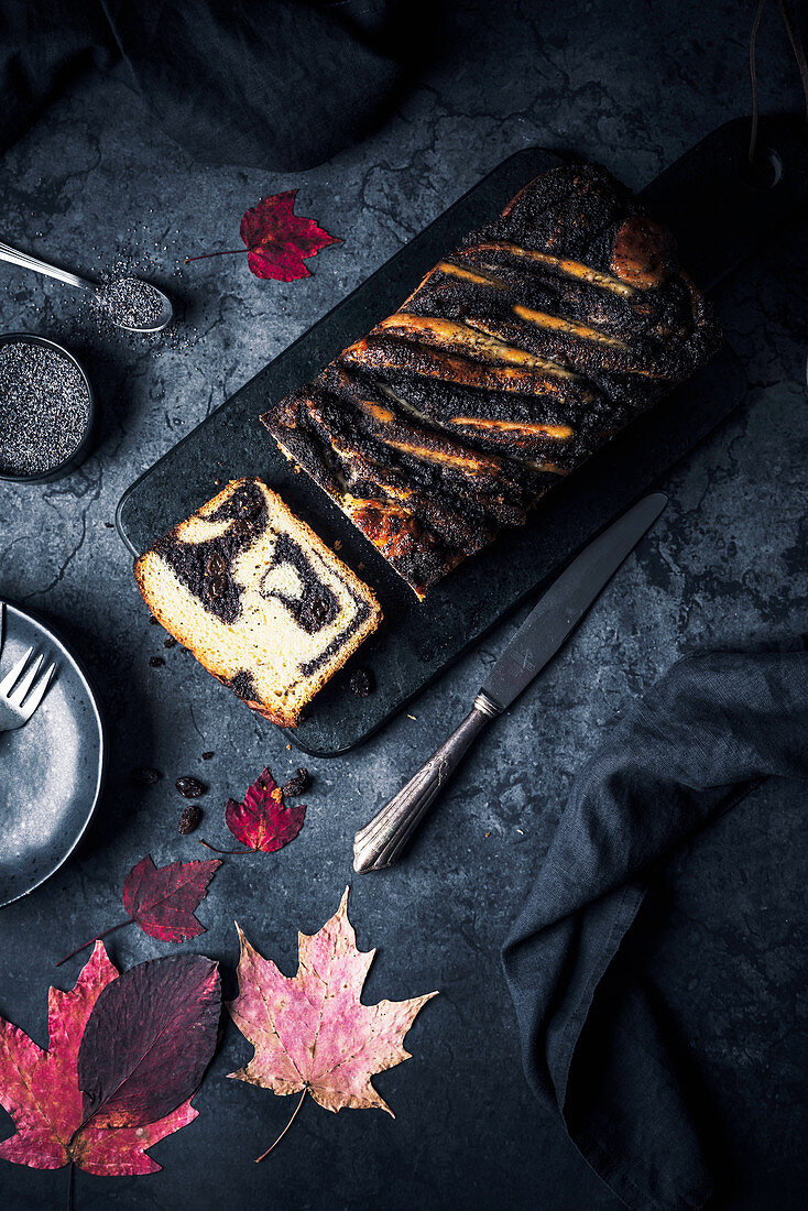 A poppyseed babka on a black surface