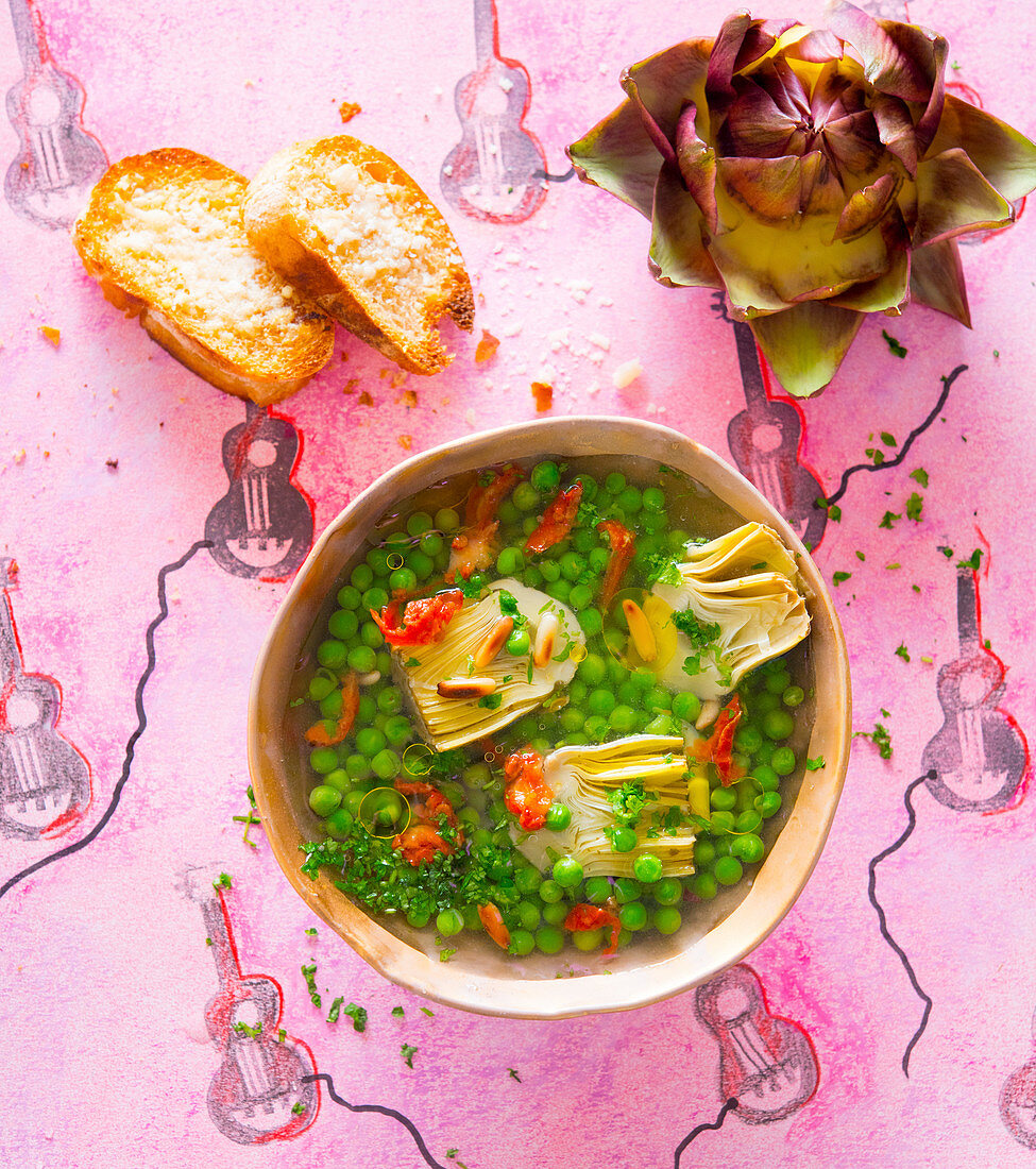 Pea and artichoke soup with dried tomatoes and pine nut crostini