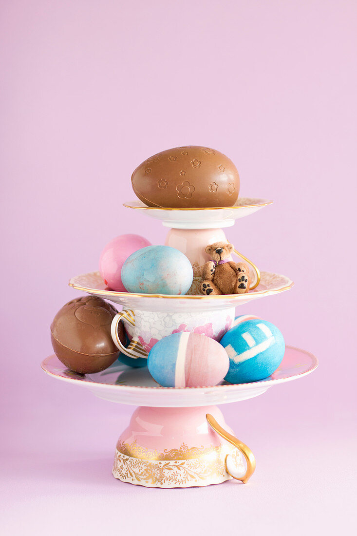 Centerpiece composition of porcelain, colourful Easter eggs and chocolate eggs