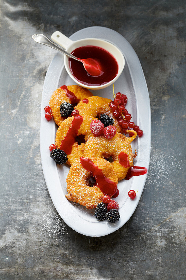 Deep-fried apple rings with a red compote sauce