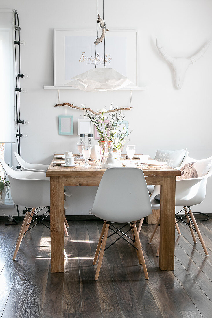 Schalenstühle am gedeckten Holztisch im Esszimmer in Weiß