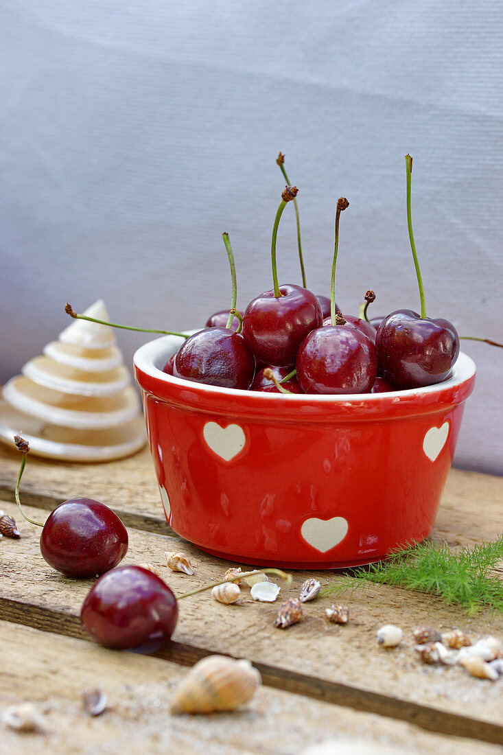 Cherries in a red ceramic bowl decorated with hearts