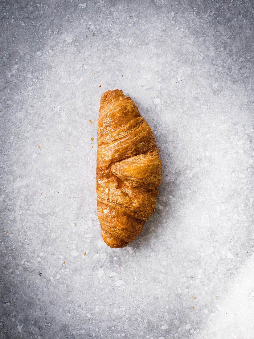 Ein Croissant auf grauem Untergrund