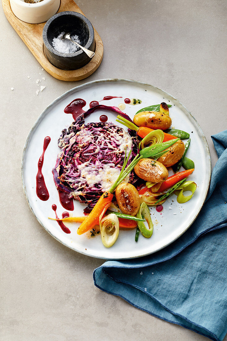 Red cabbage steak with small potatoes and spring vegetables
