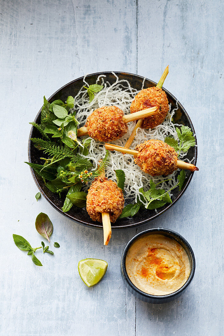 Lemongrass skewers with coriander, a peanut dip and a wild herb salad