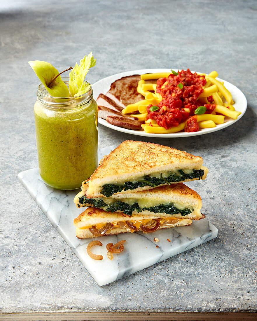 A toasted sandwich, an apple and celery smoothie and pasta with tomato sauce