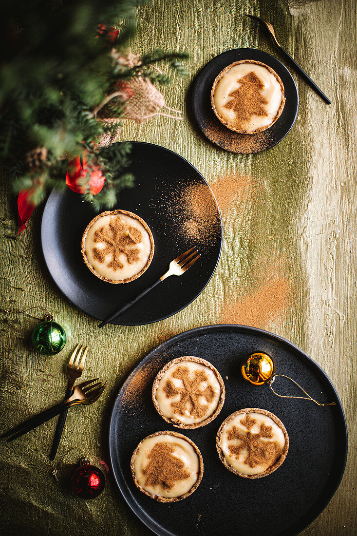 Weihnachtliche Tarteletts mit Milchcreme und Kakaopulver