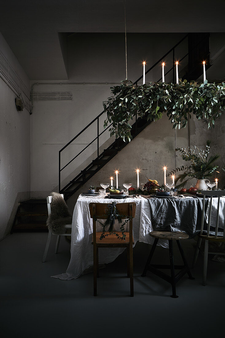 Festively decorated, candlelit dining table in loft interior