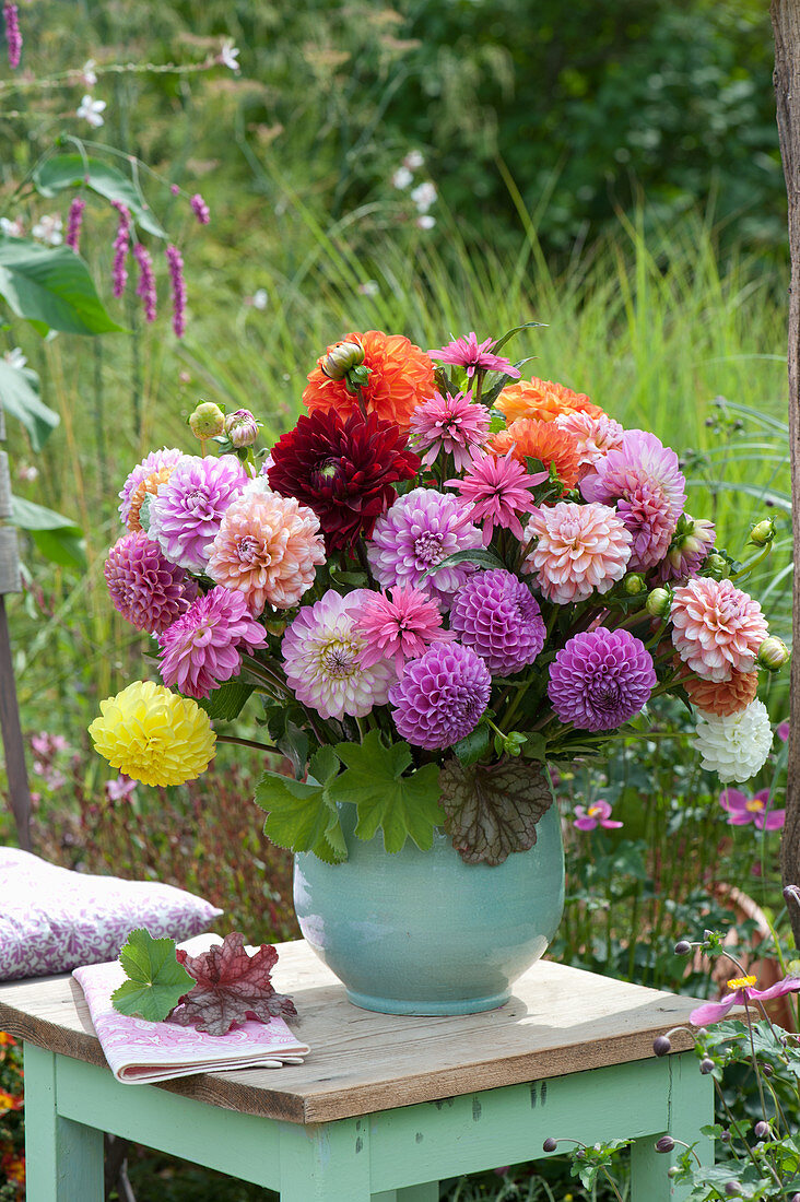 Bouquet of dahlias on stool in the garden