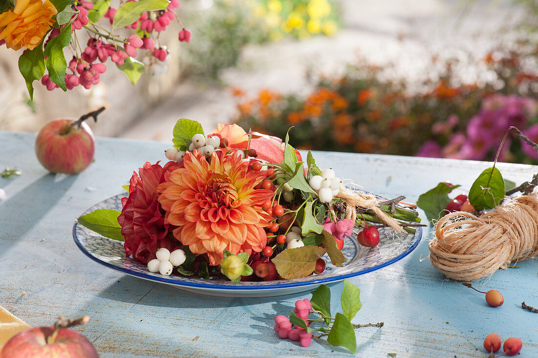 Bouquet as a plate decoration: dahlias, crackling peas, rose hips, spindle, and ornamental apples